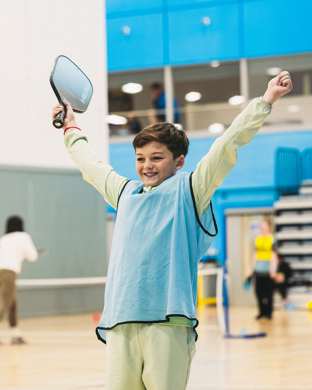 Child celebrating while playing pickleball indoors